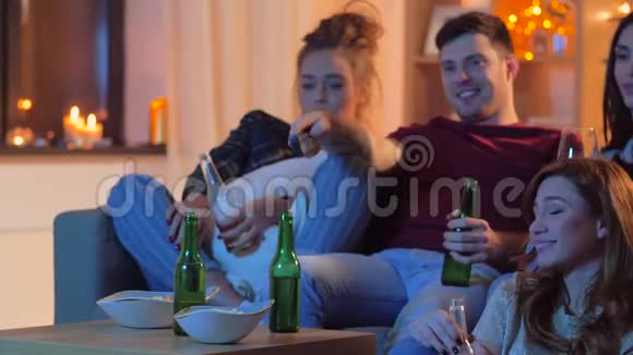 有饮料和零食的朋友在家看电视视频的预览图