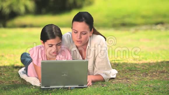 母亲和女儿在户外使用笔记本电脑视频的预览图