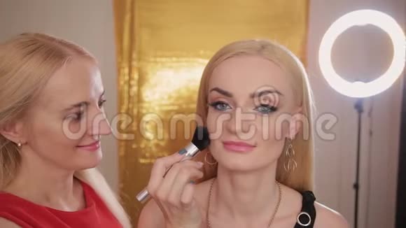 专业的化妆师使化妆成为一个非常漂亮的女人视频的预览图
