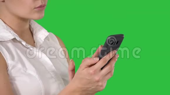 绿色屏幕上使用智能手机的美女肖像Chroma键视频的预览图