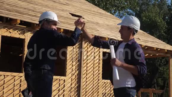 团队合作概念建筑构建建筑师慢动作视频两个男人戴头盔的生活方式握手视频的预览图