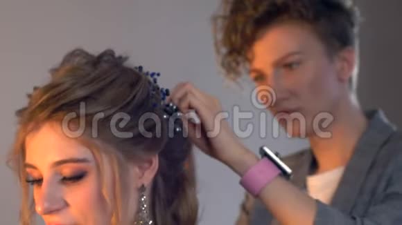 化妆师和理发师正在准备婚礼前的新娘发型短而时尚的发型设计师化妆视频的预览图