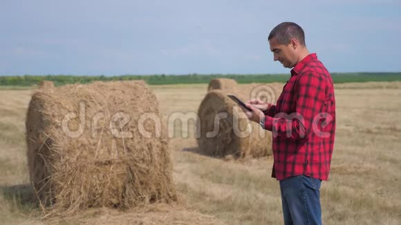 智慧农业理念男子工人农民研究干草堆在一个领域的数字生活方式平板电脑慢慢视频的预览图