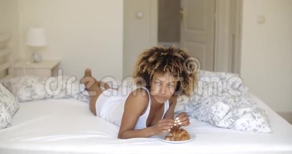年轻女子在床上享受早餐视频的预览图