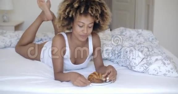 年轻女子在床上享受早餐视频的预览图