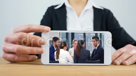 女人用电话和商务会议视频的预览图