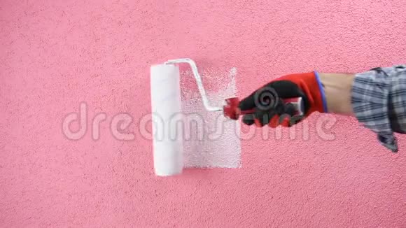 房子画家工人用白色油漆粉刷粉红色的墙建筑视频的预览图