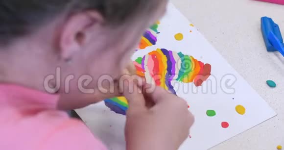 坐在办公桌前的可爱的小孩子从彩色造型塑料制成的图形中提取出不同的图形视频的预览图