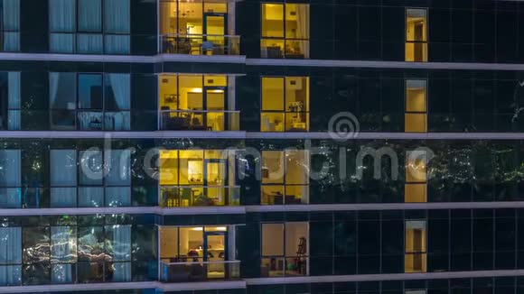 在玻璃摩天大楼的时间推移夜晚的公寓窗户会发光视频的预览图