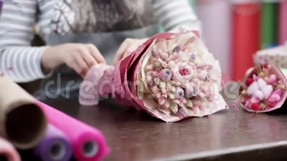快乐的花店女用纸包花她试图用一束美丽的花束谱写花朵视频的预览图