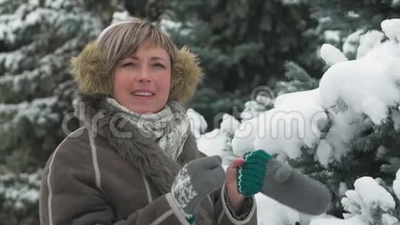 女人在冬天的森林里摆姿势美丽的风景和雪杉树视频的预览图