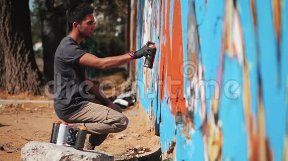 涂鸦艺术家画与气溶胶带喷雾瓶的人动作缓慢年轻的城市画家画彩色涂鸦视频的预览图