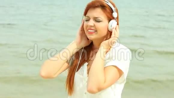 海滩上的女人听音乐视频的预览图