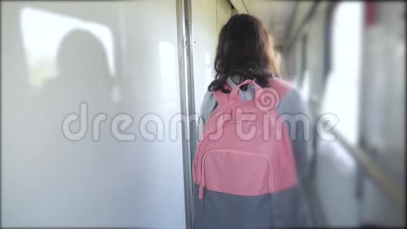 十几岁的女孩走在火车车厢里带着生活方式和背包交通运输铁路概念视频的预览图