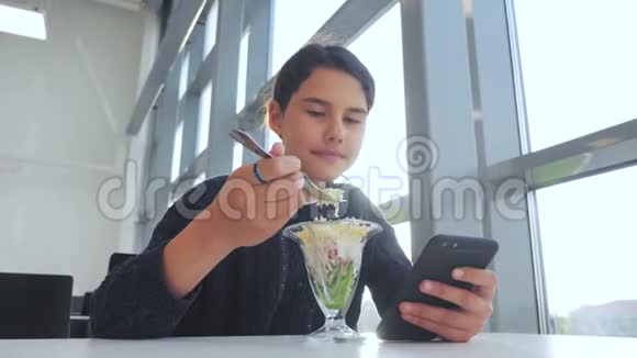 机场等待飞机航班十几岁的女孩吃沙拉看上去像智能手机在生活咖啡馆里上网机场视频的预览图