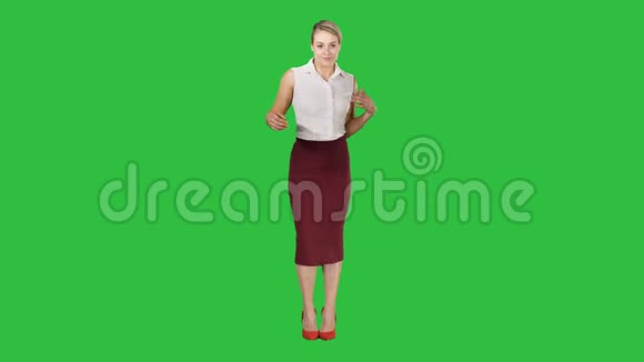 美丽快乐的年轻商务女性在绿色的屏幕上跳舞色度键视频的预览图