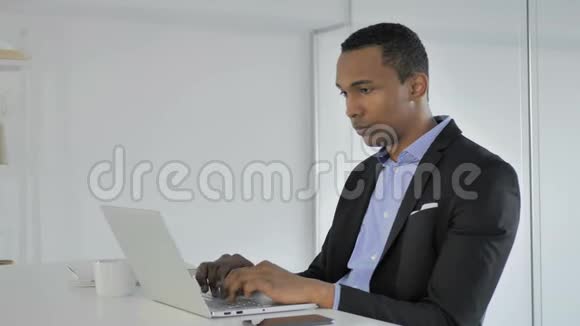 在办公室用手提电脑工作的美国黑人商人视频的预览图