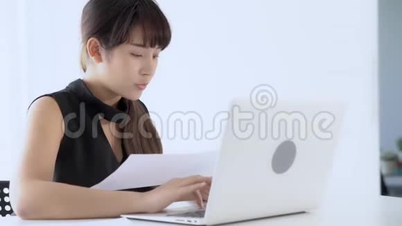 美丽的亚洲年轻女性在办公室工作用笔记本电脑打字视频的预览图