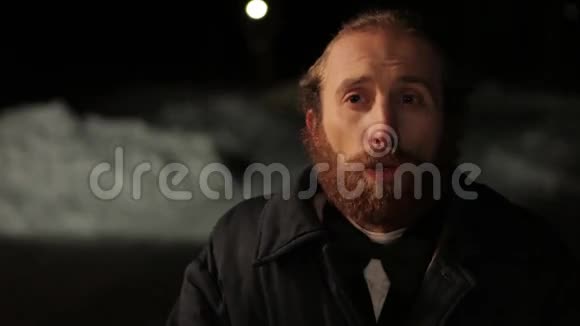穿着西装戴着领结的留着胡子的人在冬天夜晚视频的预览图