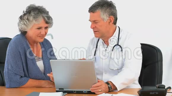 医生和病人看着笔记本电脑视频的预览图