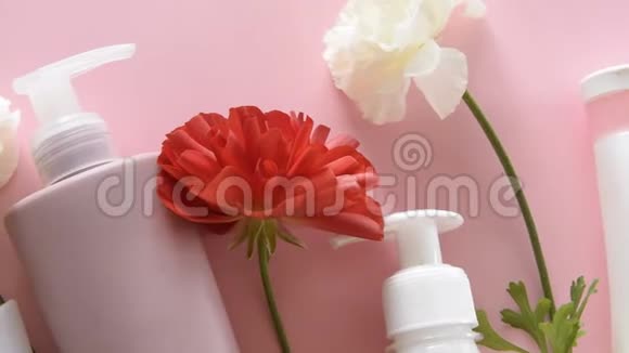 在新鲜的粉红色背景上俯瞰不同的卫生产品和花卉健康美容治疗视频的预览图