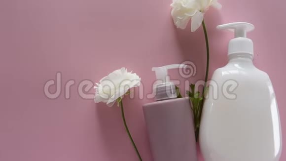 在新鲜的粉红色背景上俯瞰不同的卫生产品和花卉健康美容治疗视频的预览图