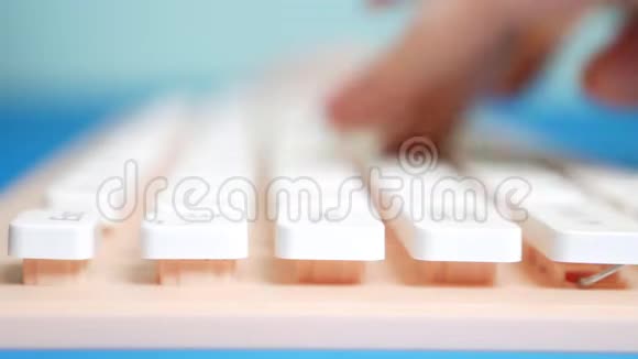 特写镜头女性的手在粉红色的键盘上打字在蓝色的背景上打字视频的预览图