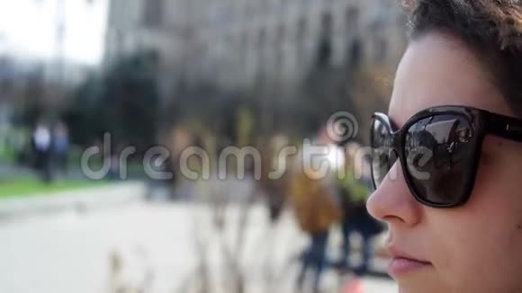 城市里戴太阳镜的年轻美女视频的预览图