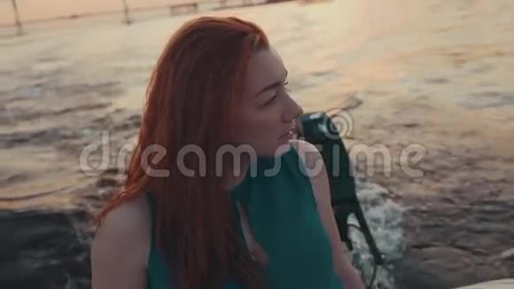 在摩托艇上穿裙子的红头发女孩美丽的夏日夜晚娱乐视频的预览图