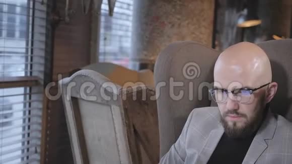 有胡子的年轻人的肖像戴着西装的眼镜看着显示器的笔记本电脑成功人士视频的预览图