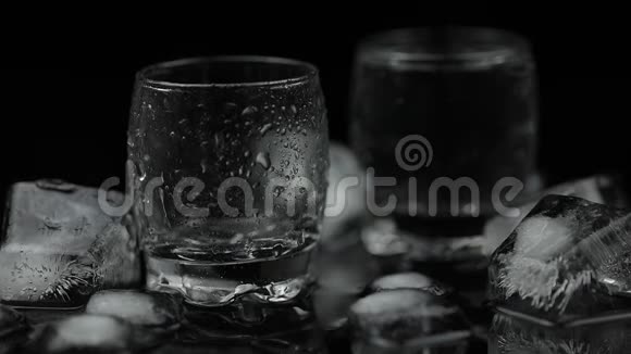 把一瓶伏特加倒入玻璃杯里黑色背景视频的预览图