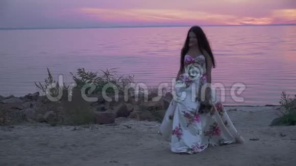 在美丽的海滩上穿着长裙子的漂亮女士视频的预览图