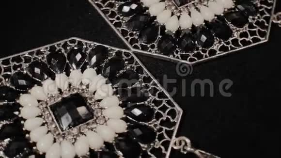 黑色旋转支架上漂亮的女性耳环高级珠宝宏观的视频的预览图