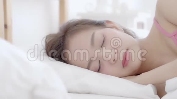 美丽的肖像年轻的亚洲妇女躺着微笑清晨日出时醒来视频的预览图