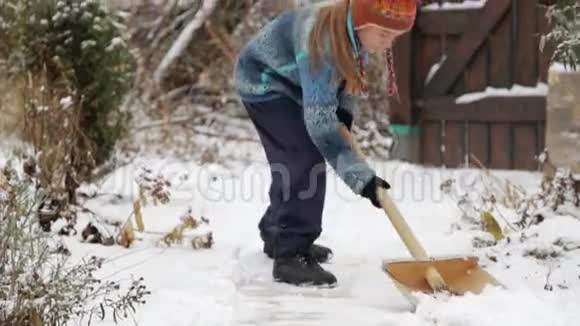 男孩在房子附近摘下雪铲冬天打扫房子附近的雪视频的预览图