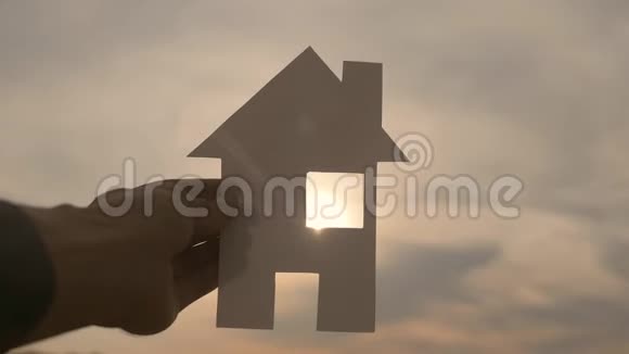 幸福家庭建设住宅理念在日落的剪影阳光下一个人手里拿着一个纸房子生活视频的预览图