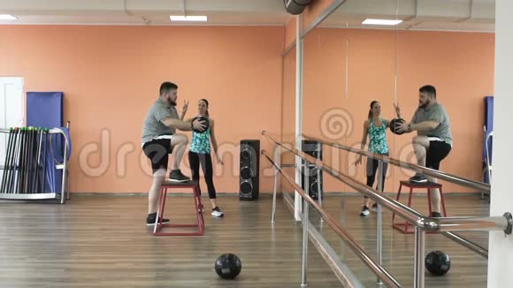超重的男性和女性教练完美的身体燃烧卡路里通过锻炼体育女孩的个人训练视频的预览图