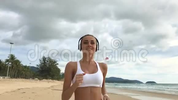 年轻的运动女子在海滩上奔跑视频的预览图