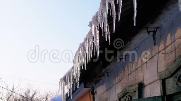 屋顶上融化的冬日冰柱正在滴水视频的预览图