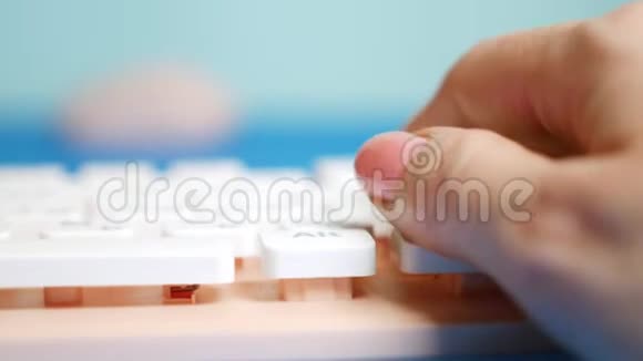 特写镜头女性的手在粉红色的键盘上打字在蓝色的背景上打字视频的预览图