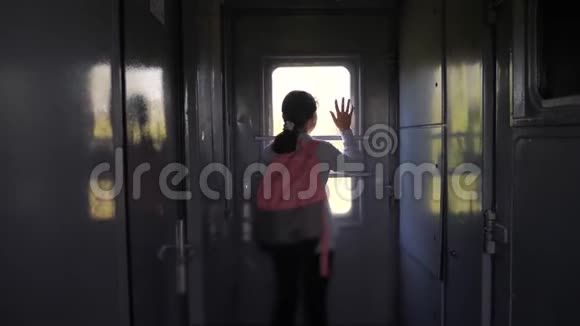 小女孩是一个乘火车旅行的背包客旅游运输铁路概念旅游女孩视频的预览图
