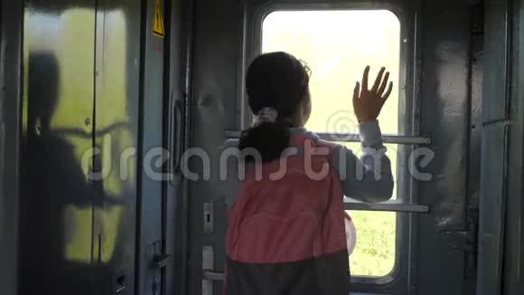 小女孩是乘火车旅行的背包客旅游运输铁路概念旅游学校的女孩视频的预览图