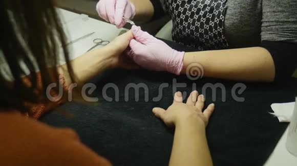 特写镜头一名妇女在美甲沙龙接受美容师用指甲锉修指甲修指甲的女人视频的预览图