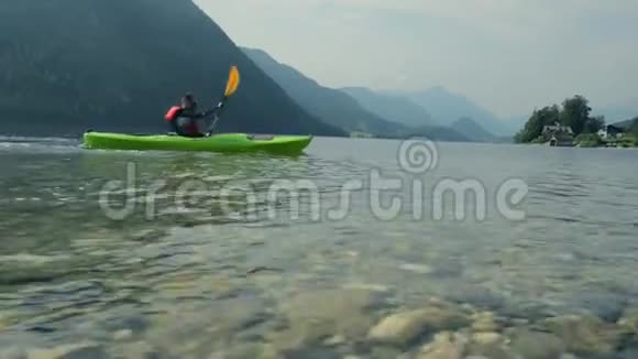 白种人皮划艇在湖边划水视频的预览图