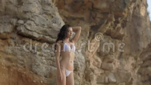 美丽的年轻女子在狂野的岩石海滩上的肖像视频的预览图