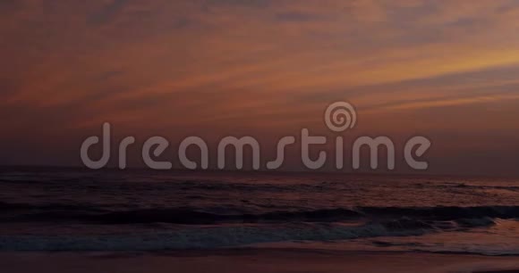 美丽的夕阳下黑沙滩和海水视频的预览图