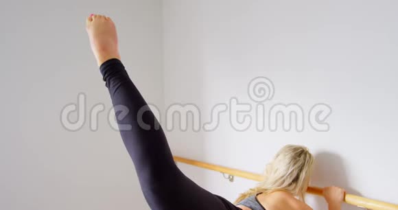 在健身室4k的酒吧里伸展身体的女人视频的预览图