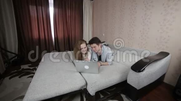 年轻快乐微笑的夫妇带着笔记本电脑视频的预览图