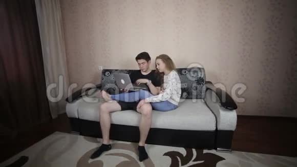 年轻快乐微笑的夫妇带着笔记本电脑视频的预览图