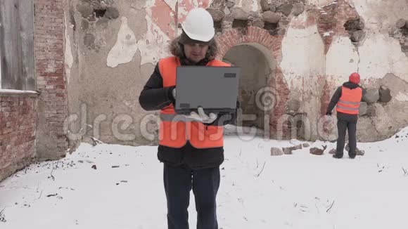 施工工程师使用笔记本电脑和步行视频的预览图